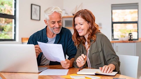 man en vrouw bekijken samen hun energiefactuur achter de laptop om energieprijzen te vergelijken